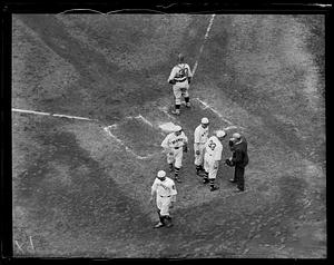 Braves players talk to umpire at home plate in game against the Pittsburgh Pirates