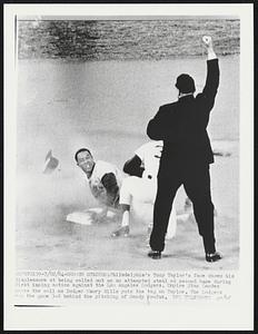 Dodger Stadium: Philadelphia's Tony Taylor's face shows his displeasure at being called out on an attempted steal at second base during first inning action against the Los Angeles Dodgers. Umpire Stan Landes makes the call as Dodger Maury Wills puts the tag on Taylor. The Dodgers won the game 3-2 behind the pitching of Sandy Koufax.