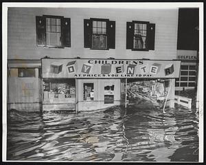 Toy Boats go Sailing and beach balls float about inside the Children's Toy Center, Peabody, as flood waters reach nearly to the display counters.