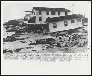 Cottages Tumbled.--This row of cottages looking south from the Kure Beach pier was sevrely damaged by high waters from hurricane Connie. The strand shows exposed rock and tree stumps.