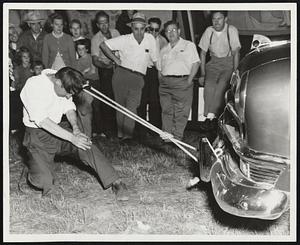 Hair Pulling Exhibition at the Marshfield Fair. Chief Black Owl, of the Old Town, Me., Indian Reservation, pulling an automobile with his locks, a feat he performs daily to entertain crowds at the fair.