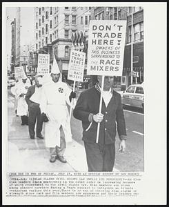 Klan Claims Civil Rights Law Swells Iis Membership-- Ku Klux Klan leaders claim membership in the robed order is increasing because of white resentment to the civil rights law. Klan members are shown among placard carriers during a Negro attempts to integrate an Atlanta restaurant earlier this year. There is no way of checking Klan claims or strength since rank and file members are anonymous and their leaders re-