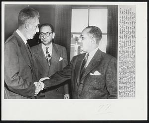 Saigh Bows Out -- Fred Saigh, owner of the St. Louis Cardinals baseball club facing a 15-months prison term for income tax evasion, gets a handshake from baseball commissioner Ford Frick, left, at the conclusion of their conference here today. Saigh plans to turn over the club's helm to a citizens' committee pending disposal of his stock in the Cardinals. Looking on at center is baseball writer Gus Steiger of the New York Daily Mirror, one of numerous sportswriters covering the dramatic meeting.