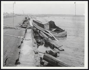 Boats in Trouble -- The Nora M., of South Dartmouth, above, rests on wreckage from the bridge between South Dartmouth and Badanaram, while below, the cruiser "Sachet" sits across a road in South Darmouth as telephone line works on a pole in the background.