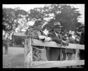 An unidentified man and woman stand by a fence