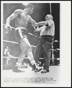 Referee Guides Fallen Champion-- Floyd Patterson, knocked out in first round, gets a helping hand from referee Frank Sikora tonight after ten count ended at 2:06 of round tonight in Chicago.