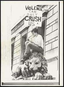 Lion Tamer--This youth sits in a decorative lion near today's antiwar demonstration in Washington while holding his sign.