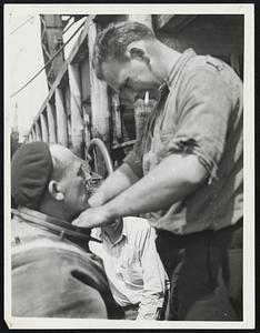 This valet has a fuzzy job in dressing the diver. Left, Bill Dunn and, right, Arthur Johnson, his tender, who always is with him on every job.