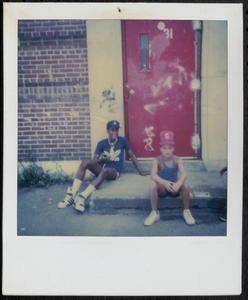 Kymio and a friend sitting in Newtowne Court