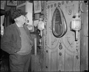 Unidentified hatted man looking at memorabilia