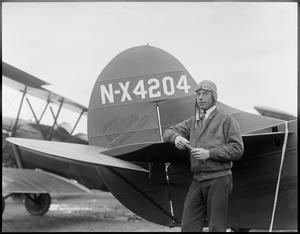 Wilmer Stultz standing side of tail of Byrd's 3-motor fokker that flies to the South Pole. Plane Friendship