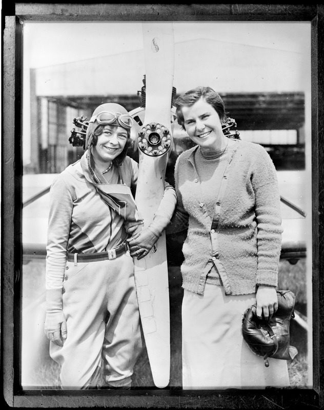 17-year-old aviator Elinor Smith posing next to propeller with 18-year-old golf star, Helen Hicks. Fairchild Field, Farmingdale, N.Y.
