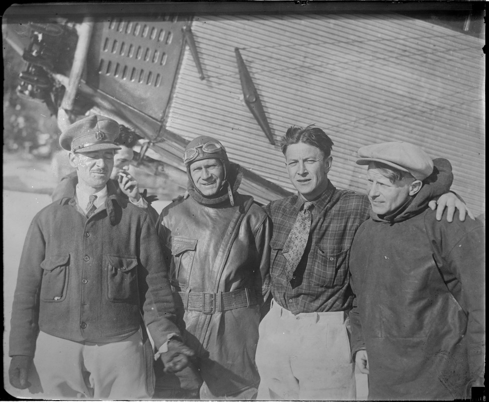 R-R: Maj. James Fitzmaurice, Irish transatlantic flyer, Floyd Bennett, pilot of Byrd's North Pole plane, Duke Schiller, who flew 1st plane to Greenly Island, and Bernt Balchen, pilot of Byrd's transatlantic flight, standing next to Ford monoplane that went to assist German fliers at Lake Ste. Agnes, Quebec.