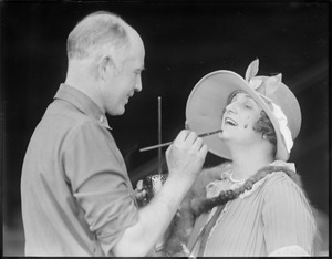 One of the "Around the World" aviators paints a woman at East Boston Airport