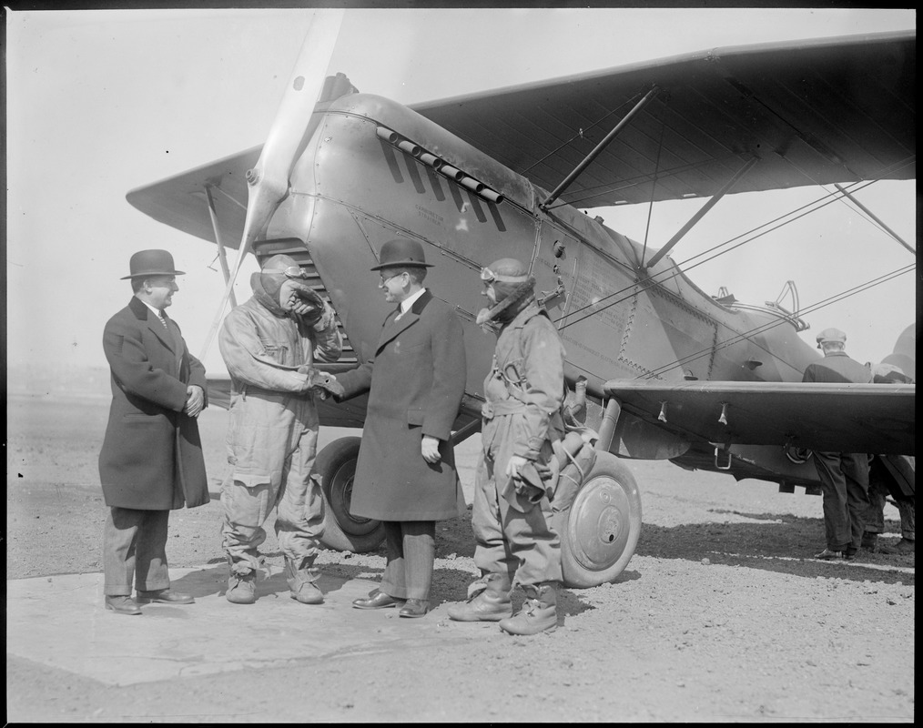Four guys in front of a bi-plane