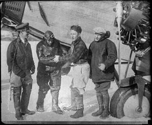 Maj. James Fitzmaurice, Floyd Bennet, Duke Schiller and Bernt Balchen standing next to Ford monoplane that went to assist German fliers. Lake Saint Agnes, Quebec.