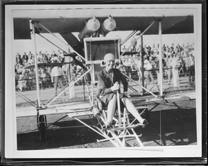 Amelia Earhart at seat of Kitty Hawk type plane