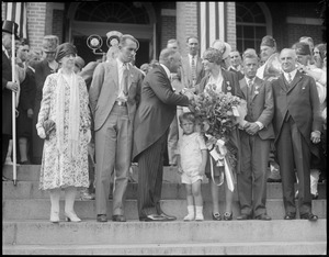 Gov. Alvan Fuller presents Amelia Earhart with a bouquet of roses, at the State House
