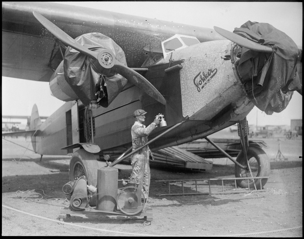 Byrd's South Pole plane at East Boston Airport being painted orange with Berryloid. It takes 8 gallons to do the job. It is weather-proof if sprayed on.