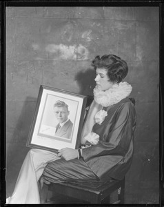 Miss Phyllis Ellsworth - pretty admirer of Lindbergh. She holds an autographed photo of Lindy signed at the American Embassy in Paris. It was purchased by Mrs. J. B. Swann of Milton for $115.