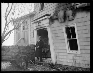 Gloucester home blown up by arson gang hired by owner Albert D. Hodson, Gloucester tax collector owner in doorway.