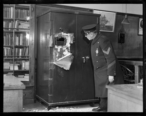 Sgt. F.V. Sullivan examining safe that youths, Theodore McDonald, Albert Monichiello, and Henry J. Benda tried to crack.