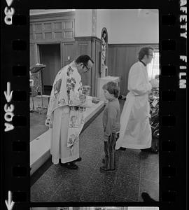 Boy receives communion at orphanage mass, Brighton