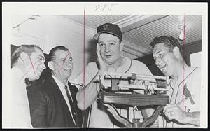 Plenty of Running is the prescription for Walker Cooper, big St. Louis Cardinals catcher, as he steps on scales in clubhouse during spring training at St. Petersburg, Fla., before watchful eye of Manager Fred Hutchinson.