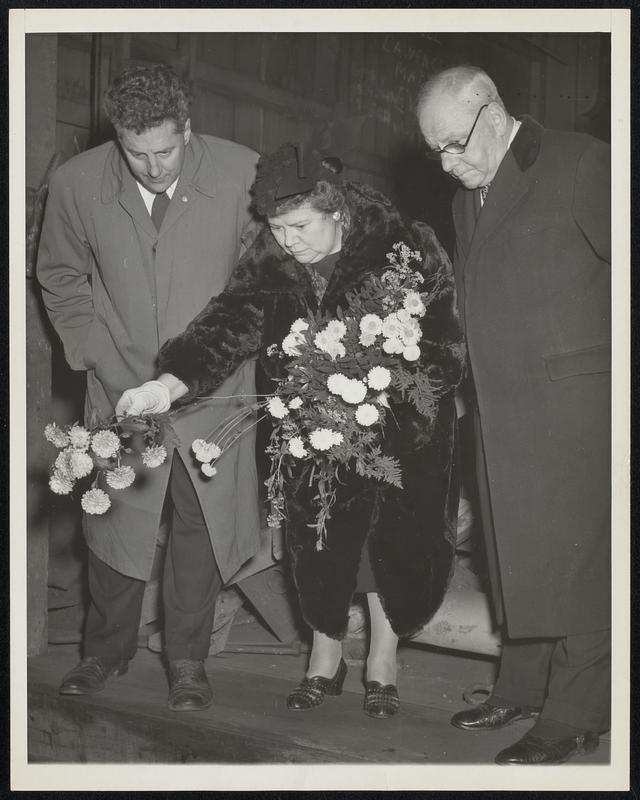 In Memory of Steamer Portland. Flowers are tossed into Boston Harbor from India Wharf, Boston, tonight (Nov. 27) in commemoration to 176 persons lost with the Steamer Portland 48 years ago today, when the Boston vessel foundered in a gale off Cape Cod. left to right: Edward Rowe Snow, Winthrope Junior High school teacher and Massachusetts Bay Historian; Mrs. Malcolm Nichols, and Mr. Nichols, former Boston Mayor.