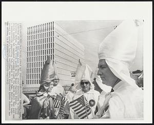 Klansmen Get Instructions--Royce McPhail, left, spokesman for the Klu Klux Klan in Texas, gives instructions to fellow klansmen before a five block march on the Texas Capitol Sunday. About thirty hooded, but unmasked klansmen stages the march which they said was a demonstration supporting U.S. policy in Vietnam. Building in background is Austin’s federal building, where President Lyndon Johnson has an office.