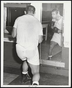 Lowell's Billy Ryan checks his form in front of mirror during workout preparatory to his fight with Joe (Rocky) Tomasello of New York at Mechanics Building tomorrow night.