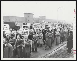 Communist-Organized parade pickets U.S. Air Force Base at Ruislip, England, to protest American rocket sites and bomber bases. British authorities report many pacifists fell in line as willing dupes.