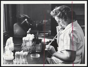 Mrs. Hary Henry of Wellesley, a bacteriologist, uses pipette to take germ count on utensils.