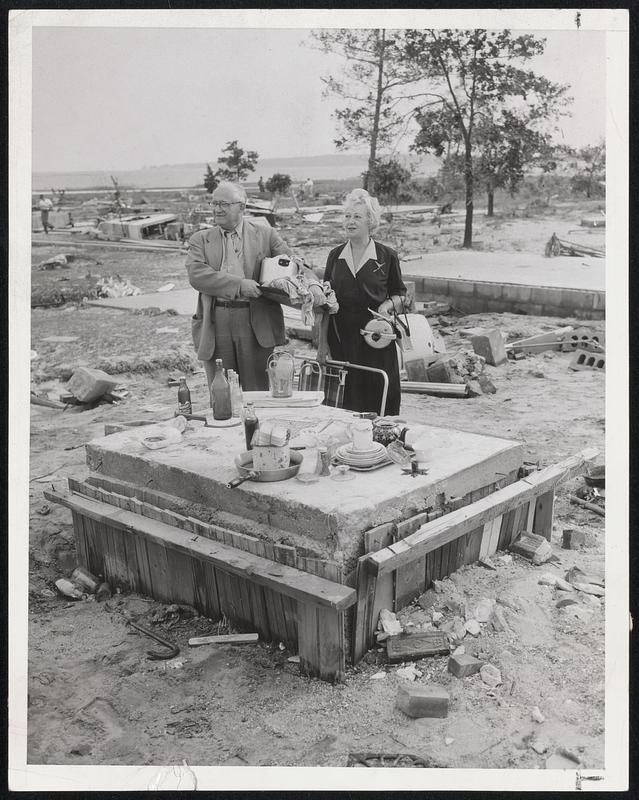 Meal-Time, Post-Hurricane Style, is arranged by Mr. and Mrs. Boris Volger of Brighton on block of cement of Swifts Beach, Wareham. The beach about it littered with fragments of houses, furniture and shredded trees.