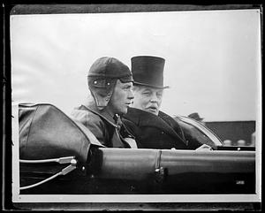 Charles Lindbergh seated next to an unidentified man in an automobile