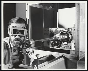 Moon Shine. Engineer Robert C. Guyer checks out a laser system that will be in operation on the Apollo 15 Spacecraft as it orbits the moon next month. The laser is part of an altimeter system developed by the RCA Aerospace Systems Division in Burlington, Mass. With its "eyes" exposed, the altimeter will bounce its beams off the moon to not only map the varying features of the lunar surface, but also provide constant precise measurement of the altitude of the Command Module.