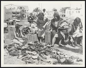 Shoes for Earthquake Victims. This open-air shop at Compton, Calif., operated by the Inglewood Auxiliary of the American Legion, provided free shoes for earthquake victims. The photograph shows business booming March 14 as needy victims helped themselves.