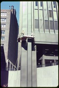 Men going up the side of a building on a platform