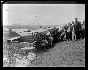 A crowd of people looking at a damaged airplane