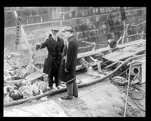 A police officer speaking to an unidentified man by some debris