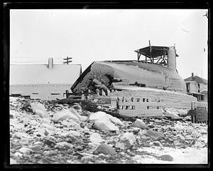 Ice covered boat on its side out of the water, probably after a storm