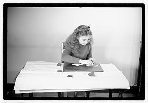 A girl matching fitting shapes in a puzzle