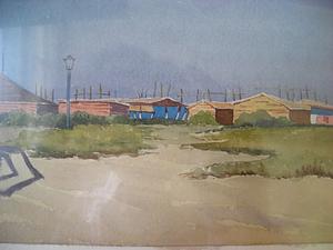 Sandy foreground, with grassy patches, leads back to