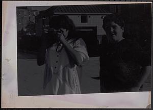 Two people, one with a camera taking a photograph at Newtowne Court
