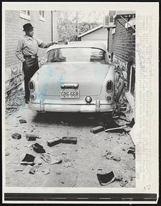 Checking earthquake damage, Arthur Lyons, St. Louis, removes brick from the top of his car that was damaged when a neighbor's chimney fell on Lyon's car, 11/9. An earthquake shook the St. Louis area, as well as other parts of the midwest, and caused some minor damage to homes and buildings.