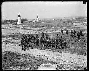 A group of police, some running, on a beach