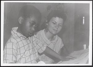 Boy making art with a teacher