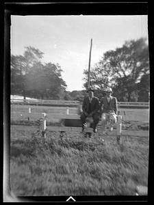 Two men on a wooden fence