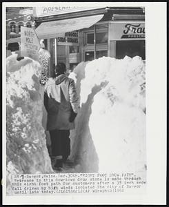 Bangor, Maine. - "Eight Foot Snow Path". Entrance to this downtown drug store is made through this eight foot path for customers after a 35 inch snowfall driven by high winds isolated the city of Bangor until late today.