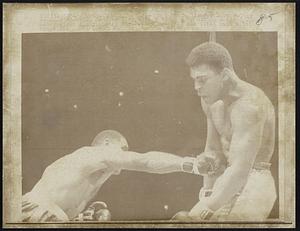 Challenger Zora Folley reaches champion Cassius Clay with a long punch during their 3/22 heavyweight champion fight. Clay retained his title with a 7th round KO.